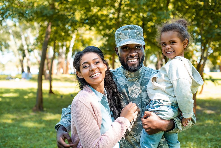 an African-American Army man, smiling with his family